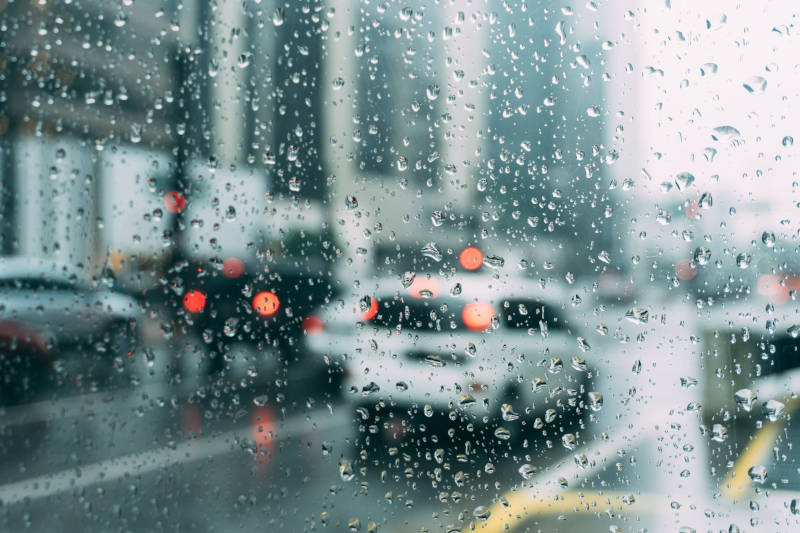 Car driving in traffic with rain on the window